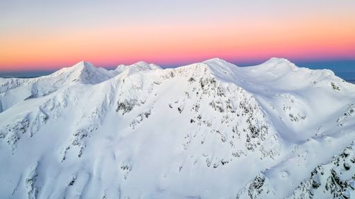 A beautiful view of a snow-covered mountain against a colorful pastelsunrise sky