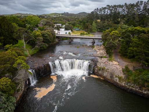 An aerial shot of Haruru Falls surrounded by greenery in Northland, New Zealand