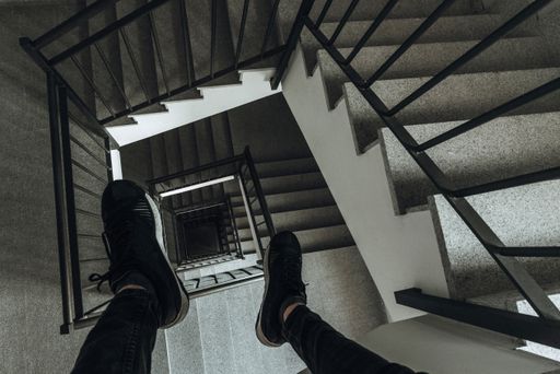 A high angle shot of a person's legs over the stairs of a building