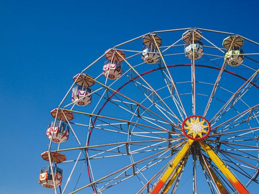 A closeup of a colorful Ferris wheel in the amusement