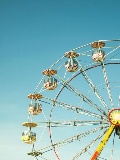 A closeup of a multicolored Ferris wheel in the amusement park