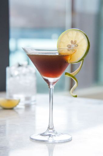 A vertical shot of a delicious alcoholic cocktail with garnish at the bar