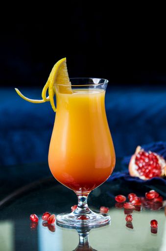 A vertical shot of a delicious alcoholic cocktail with garnish at the bar