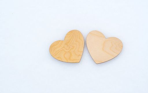 Valentine's day, two wooden hearts lie on white snow