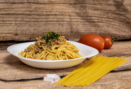 A closeup shot of delicious spaghetti bolognese in a white plate
