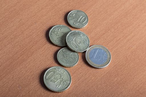 A high angle shot of a pile colorful euro coins on wooden table surface