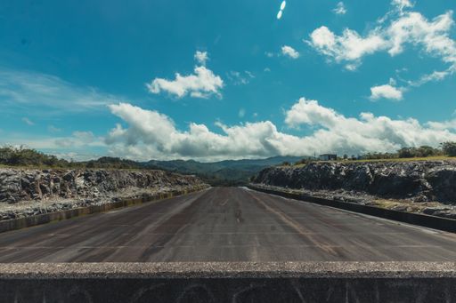 An asphalt road in an industrial area under a beautiful cloudscape
