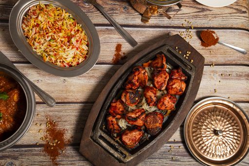 A top view of deliciously seasoned and prepared Tandoori chicken, Indian curry and Basmati rice