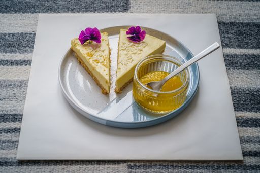 A closeup sh of two slices of delicious cake and a bowl of sauce