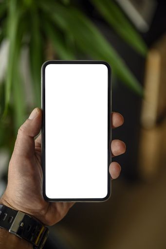 A vertical shot of a hand holding a smartphone with space for text