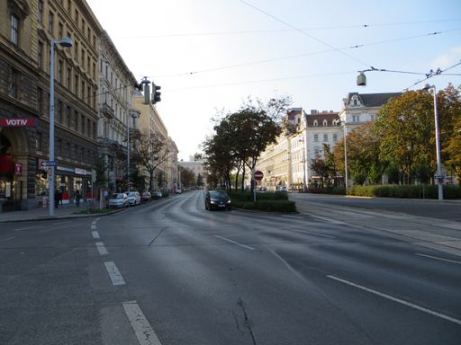 A wide angle shot of a street surrounded by trees and greenery