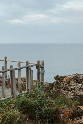 A landscape of the cliff protected with wooden railing overlooking the Cantabrian Sea