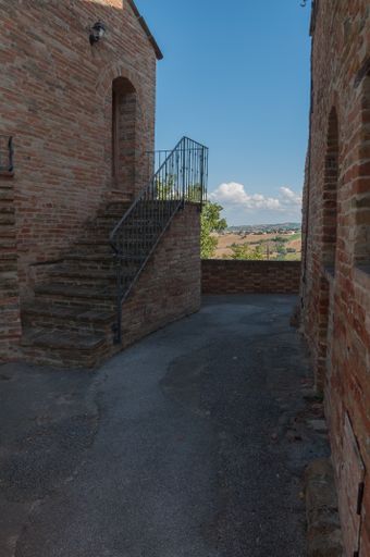 A vertical shot of a black metal staircase leading to a brick house entrance