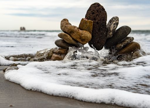 A selective focus shot of an arch of rocks on the sandy beach