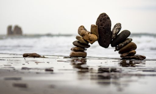 A selective focus shot of an arch of rocks on the sandy beach