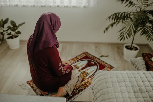A closeup shot of a Muslim female praying on a carpet