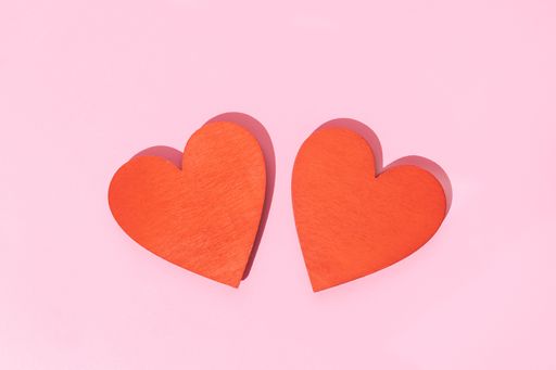 Two Wooden red heart shape isolated on pink background. Couple love concept