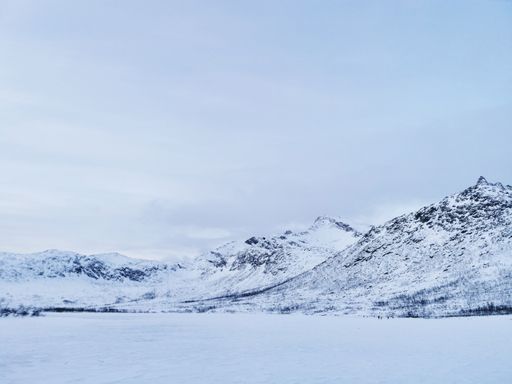 A beautiful shot of the frozen Kattfjordvatnet lake and snowy mountains in Norway
