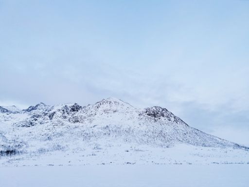 A low angle shot of snow-covered hills in Kvaloya island, Norway during winter