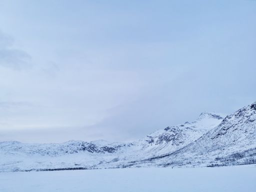 A beautiful shot of the frozen Kattfjordvatnet lake and snowy mountains in Norway