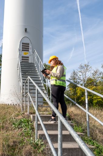 A portrait shot of a woman engineer looking at her tablet while walking