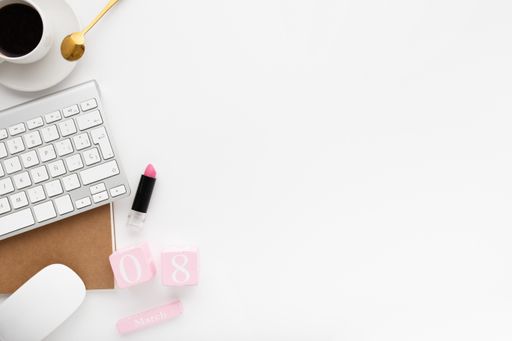 An overhead shot of a workspace desk on a white background - women's day concept