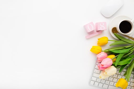An overhead shot of a workspace desk on a white background - women's day concept