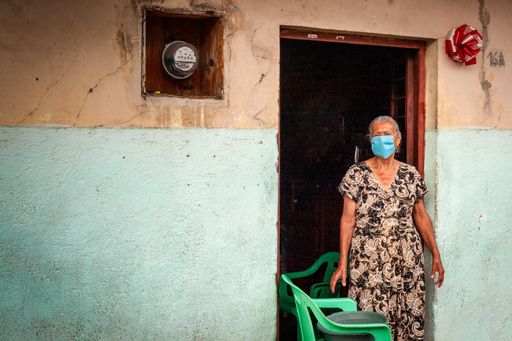 Older woman from Queseria, Colima in Mexico washes outside her door on the sidewalk