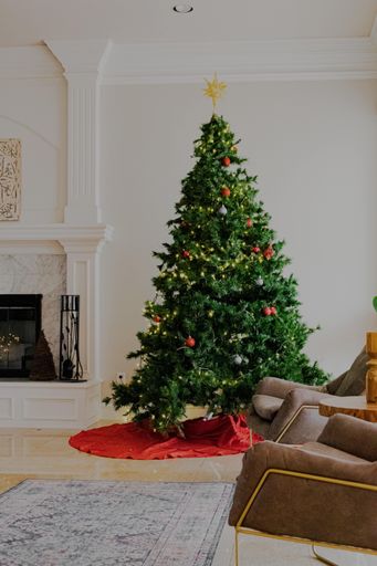 A vertical shot of a modern house interior with a beautifully decorated Christmas tree at daytime