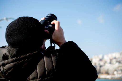 A closeup shot of a male taking a photo of the sky with a camera