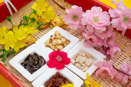 Tet Holiday, Lunar new year, chinese new year concept . Dried sunflower, lotus, watermelon and pumkin seeds top view isolated on yellow
