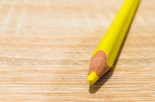 A closeup shot of a yellow pencil on a wooden surface
