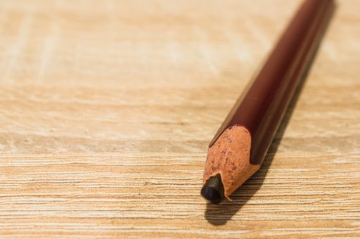 A closeup shot of a brown pencil on a wooden surface