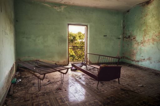 An interior shot of an old abandoned building with cracked up walls in Italy