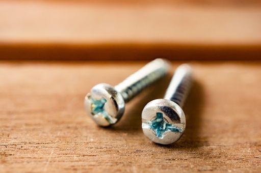 A closeup shot of screws on a wooden surface with a blurry background