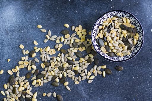A top view of Sunflower and pumpkin seeds on a blue surface