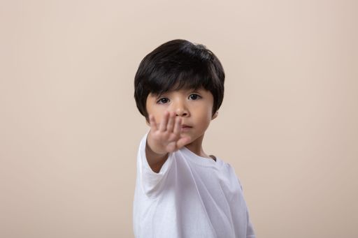 A young Hispanic boy showing stop gesture.