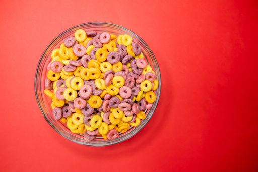 A top view of breakfast cereal rings in bowl isolated on red background