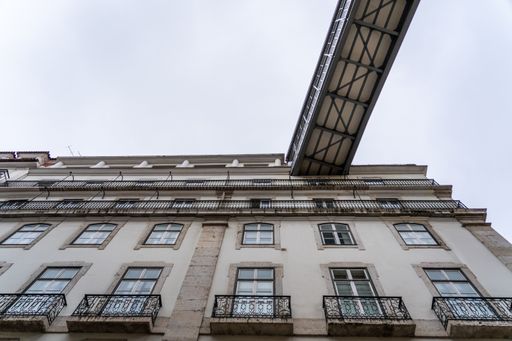 A low angle shot of a bridge connecting with a building in Poland under a cloudy sky