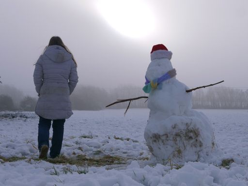Hiker with snowman in winter with scarf and hat wide shot