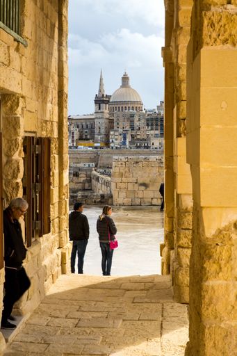 Seen through Fort Manoel passage way, Our lady of Mount Carmel church's prominent dome, the walls and buildings of Valletta, capital city of Malta
