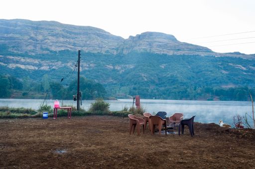 A beautiful landscape of camp and tents with hills in the background at Arthur Lake in Bhandardara in Maharashtra, India