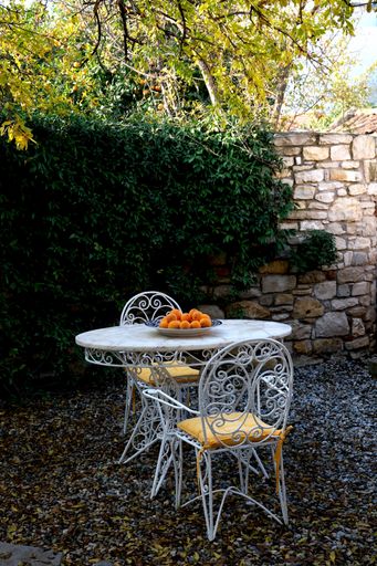 A vertical shot of a marble table with creative chairs in a garden