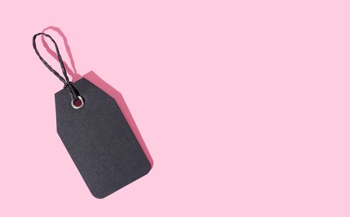 Template of black cardboard price tag isolated on pink background. Copy space