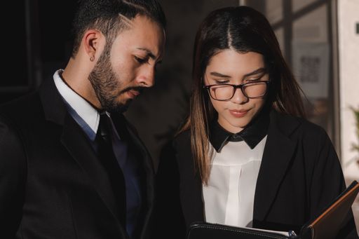A portrait of a beautiful female with optical glasses and a handsome male reading something together