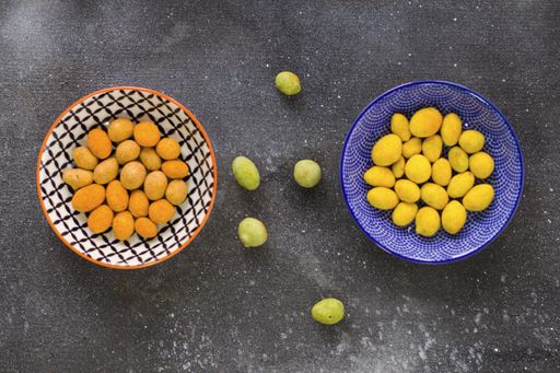A top view of almonds, cashews and coasted nuts in bowls on the table