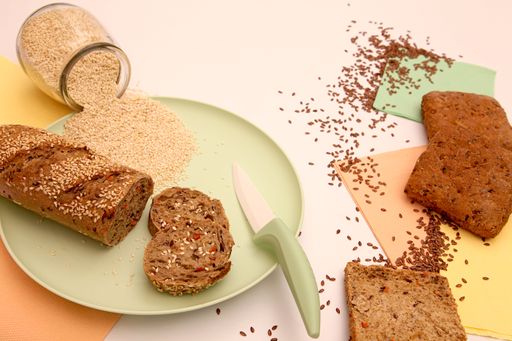 Still life of bread and scattered seeds on a light background.