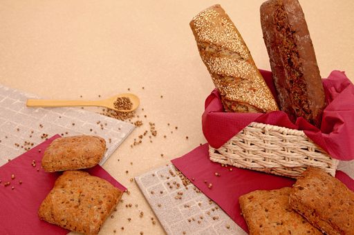 Still life of different types of bread and coriander seeds.