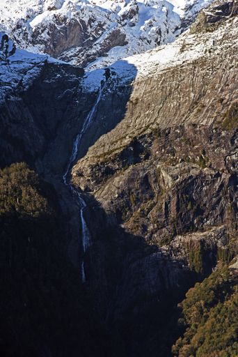 A vertical shot of a stiff snowy mountain