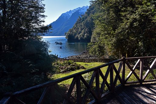 The wooden fence near the lake and forest and mountains